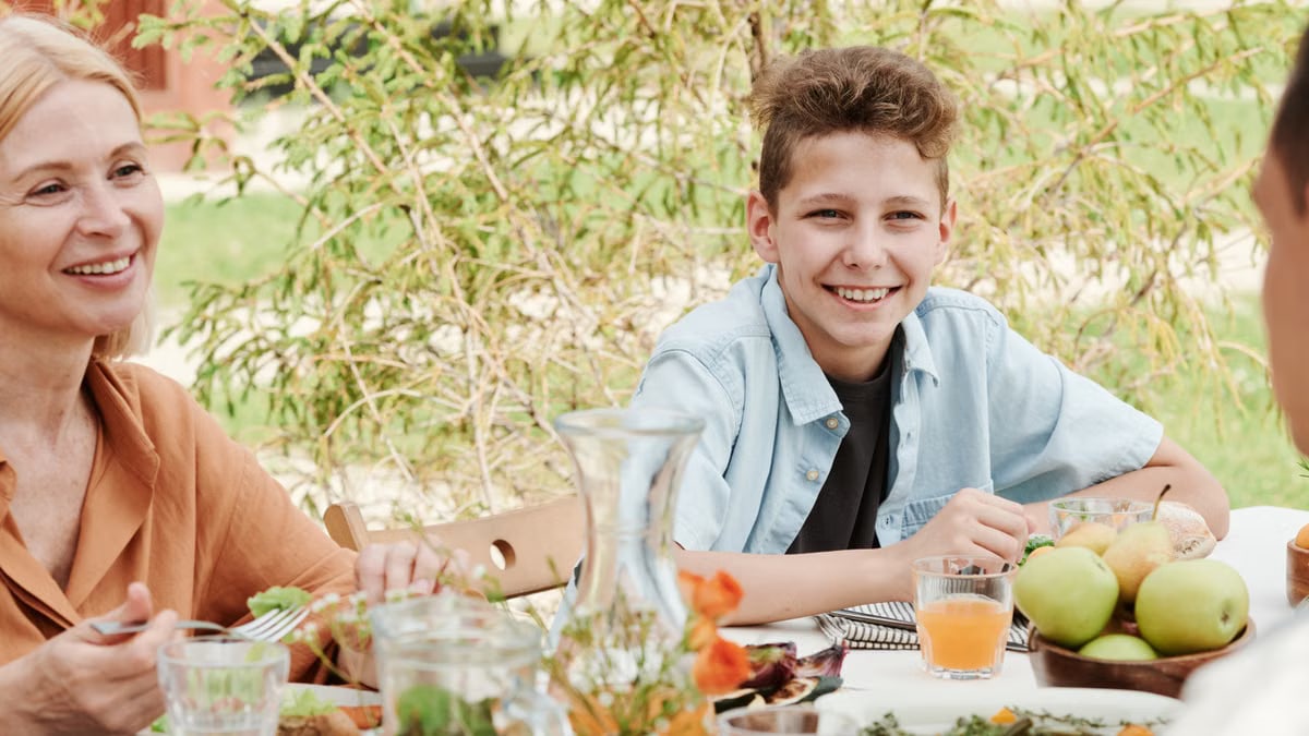 Smiling family of four dining outdoors, capturing moments of togetherness.